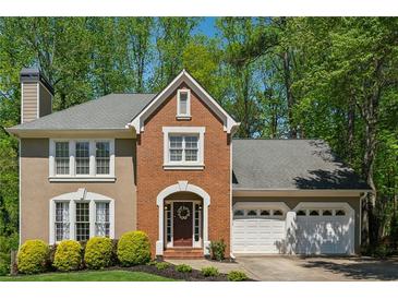 Charming two-story home features a brick facade, attached two-car garage and mature landscaping at 3362 Timber Rdg, Powder Springs, GA 30127