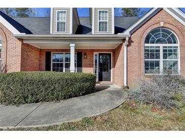 Welcoming brick home entrance featuring a covered porch and arched window at 90 Ashford Dr, Oxford, GA 30054
