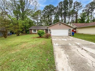 Charming single-story home featuring a stone facade, a two-car garage, and a well-maintained front yard at 245 Adena W Ln, Atlanta, GA 30349