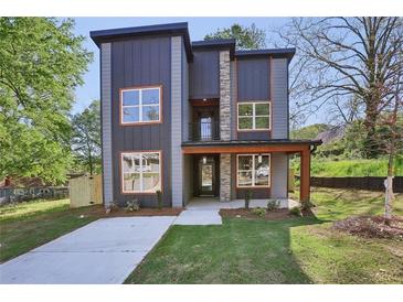 Contemporary two-story home with large windows, a stone facade, modern siding, and a well-manicured lawn at 1002 Coleman Sw St, Atlanta, GA 30310