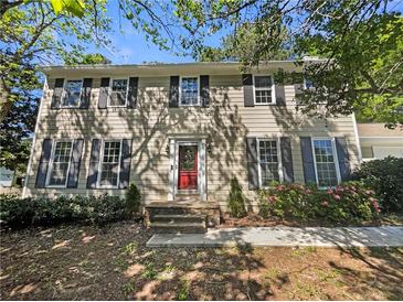 Traditional two-story home with a red front door, black shutters, and manicured landscaping at 2907 Clearbrook Dr, Marietta, GA 30068