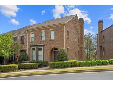 Charming brick home with manicured landscaping and beautiful architectural details under a partly cloudy blue sky at 3105 Neal Ct, Cumming, GA 30041