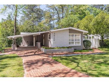 Charming gray brick home with brick walkway, manicured lawn, and carport at 3860 Carlton Dr, Atlanta, GA 30341