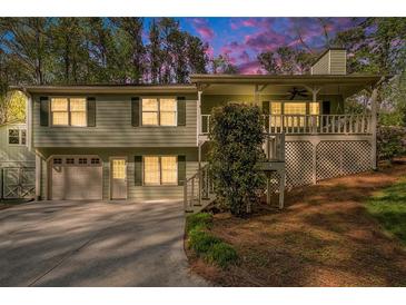 Charming two-story home with a covered porch, attached garage, and lush landscaping at 1855 Mountain Trce, Canton, GA 30114