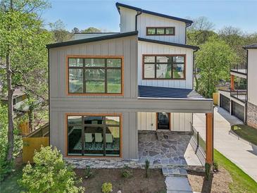 Stunning two-story modern farmhouse with gray siding, wood trim windows, and a charming stone porch at 1140 Hubbard Sw St, Atlanta, GA 30310