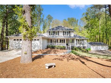 Charming two-story home with a welcoming front porch and a well-manicured lawn at 1931 Mceachern Manor Sw Dr, Marietta, GA 30064