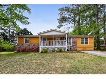 Charming single-story home featuring a welcoming front porch and a well-maintained lawn at 2529 Ridgecrest Nw Dr, Kennesaw, GA 30152