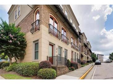 Modern townhome with brick and cream-colored facade, balconies, and manicured landscaping at 384 16Th Nw St # 1, Atlanta, GA 30363