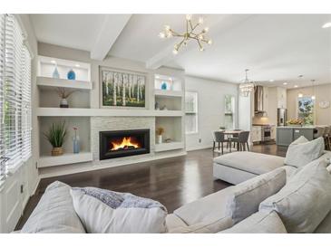 Bright living room featuring a cozy fireplace, built-in shelving, and modern lighting at 823 Canterbury Overlook, Atlanta, GA 30324