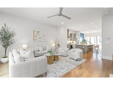 Bright, open-concept living room featuring hardwood floors and modern white furniture at 332 Gibson Se St, Atlanta, GA 30316