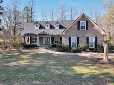 Charming brick home featuring a well-manicured lawn, covered porch, and inviting curb appeal at 4111 Alayna Lee Cir, Mcdonough, GA 30252