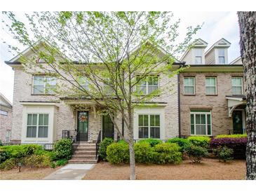 Charming brick townhome featuring a landscaped front yard and inviting entryway at 1323 Faircrest Way, Suwanee, GA 30024