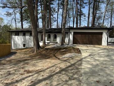 Inviting exterior view of a single-story home with well-maintained landscaping and attached garage at 3185 Hammarskjold Dr, East Point, GA 30344
