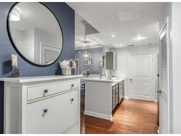 Stylish entryway with a round mirror, accent wall, and wooden floors at 1101 Juniper Ne St # 415, Atlanta, GA 30309