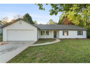 Charming single-story home featuring a manicured lawn, attached garage, and classic vinyl siding at 175 Cypress Dr, Covington, GA 30016