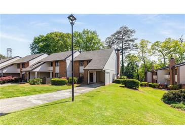 Inviting townhome featuring manicured lawn, mature trees and convenient covered parking at 3228 Clairmont North Ne # 3228-A, Brookhaven, GA 30329