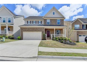 Beautiful two-story home with a brick facade, two-car garage, and a welcoming front porch and landscaped yard at 4349 Northmark Ln, Buford, GA 30518
