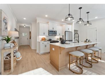 Bright, open kitchen featuring a large island with seating, stainless steel appliances, and modern pendant lighting at 432 Carrera Ln, Acworth, GA 30102