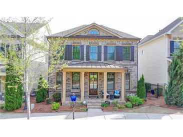 Charming two-story home with a welcoming front porch, beautiful landscaping, and meticulous yard at 6425 Bellmoore Park Ln, Johns Creek, GA 30097