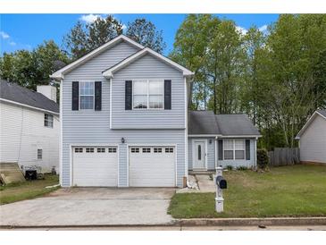 Charming two-story home with blue siding, a two-car garage, and a well-manicured lawn at 2565 Feywood Ct, Lithonia, GA 30058