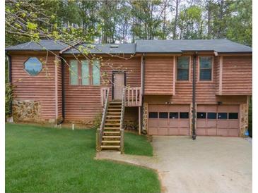 Charming home featuring wood siding, a two-car garage, and a neatly maintained front yard at 4020 Cranwood Dr, Atlanta, GA 30349
