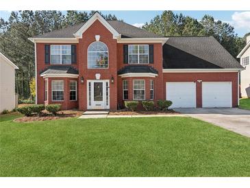 Charming two-story red brick home with a well-manicured lawn and a two-car garage at 192 Palisade Point Dr, Ellenwood, GA 30294