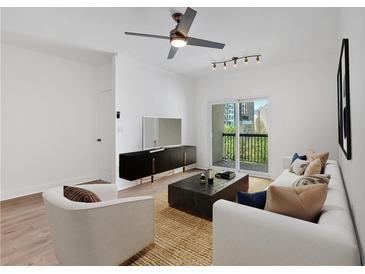 Bright living room features a ceiling fan, modern furniture, and a sliding glass door leading to the outside at 1075 Peachtree Ne Walk # A421, Atlanta, GA 30309