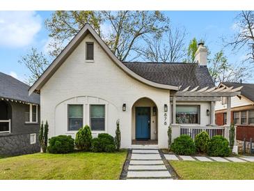 Charming, renovated home features a blue door, crisp white brick, a landscaped yard, and inviting curb appeal at 878 Dill Sw Ave, Atlanta, GA 30310
