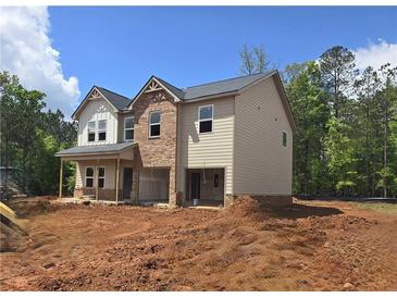 New construction home with a two-car garage, brick and tan siding, and an unfinished lawn at 1594 Sungrown Way, Mcdonough, GA 30253