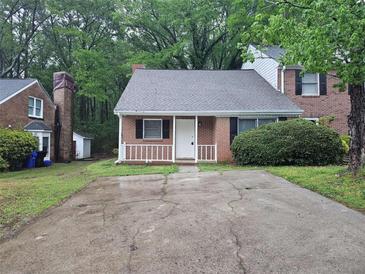 Charming brick home featuring a cozy front porch and a well-maintained yard, perfect for comfortable living at 200 Williamsburg Way, Fayetteville, GA 30214