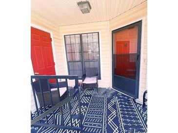 Cozy patio area with woven chairs and a stylish blue patterned rug, perfect for relaxing outdoors at 705 Windchase Ln, Stone Mountain, GA 30083