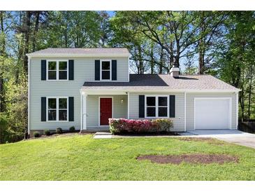 Charming two-story home with a well-maintained lawn, a red front door and lush landscaping at 2965 Carrie Farm Nw Rd, Kennesaw, GA 30144