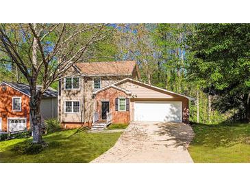 Charming two-story home boasts a two-car garage and a welcoming brick entryway at 144 Grayland Hills Ct, Lawrenceville, GA 30046