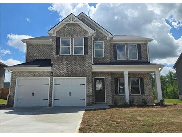 Charming two-story home with brick facade, black shutters and a two-car garage at 1613 Fuma Leaf Way, Mcdonough, GA 30253