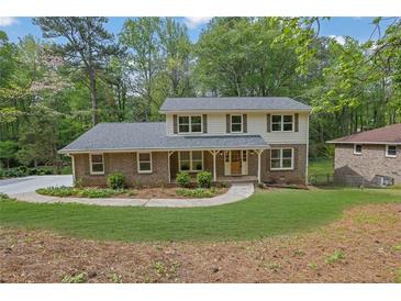 Charming two-story home features a brick facade, gray roof, and a well-manicured lawn at 3512 Hidden Acres Drive, Atlanta, GA 30340