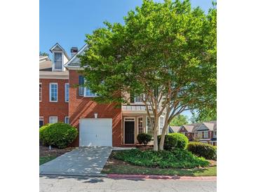 Charming brick home with a two-car garage, lush landscaping, and mature trees at 2361 Maplewood Ct # 25, Atlanta, GA 30339