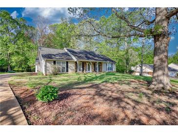 Charming single story home with a traditional facade, covered front porch and well manicured lawn at 260 Eastwood Forest, Covington, GA 30014