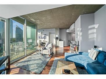 Bright open-concept living room featuring hardwood floors, expansive windows, and city views at 3324 Peachtree Ne Rd # 1518, Atlanta, GA 30326