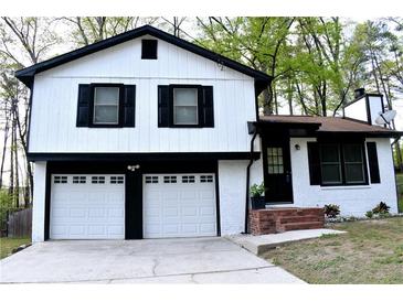Charming two-story home boasts a white exterior with black accents and a two-car garage at 3867 Cherie Glen Rd, Snellville, GA 30039