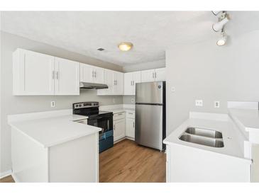 Bright kitchen featuring stainless steel appliances, white cabinetry, and modern countertops at 1066 Rock Creek Ln, Norcross, GA 30093