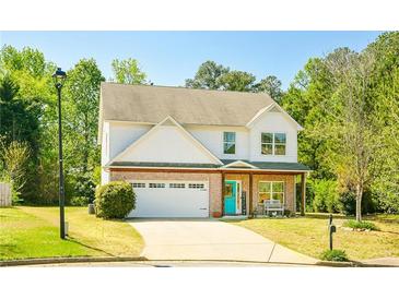 Two-story home features a well-maintained lawn, a two-car garage, brick accents and a welcoming entrance at 2365 Oakland Trail Way, Lawrenceville, GA 30044