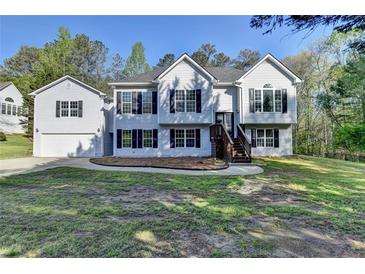 Charming two-story home with light siding, dark shutters, front yard and an attached garage at 3211 Thompson Mill Rd, Buford, GA 30519