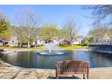 Community pond view with fountain, bench, and lovely landscaping offering a serene outdoor space at 3858 Vineyards Lake Nw Cir # U-19, Kennesaw, GA 30144