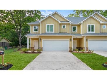 Charming townhouse featuring a well-manicured lawn, attached garage, and inviting facade at 6860 Robinson St, Lithonia, GA 30058