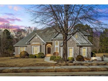 Charming brick home with a manicured front yard, mature trees, and a beautifully designed roofline at 135 Antoinette Ave, Mcdonough, GA 30252