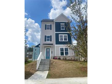 Charming two-story home with a well-manicured lawn and inviting blue front door at 2719 Stream Valley Nw Ln, Atlanta, GA 30318