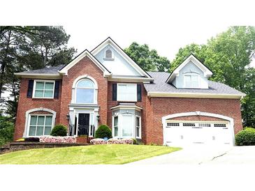Beautiful brick home with attached garage, arched window and manicured front yard at 1081 Talon Trce, Lawrenceville, GA 30043