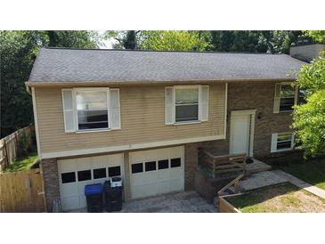 Inviting two-story home features a two-car garage, brick accents, and a neatly maintained front yard at 1425 Parkmont Dr, Roswell, GA 30076