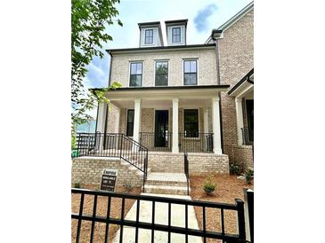 Beautiful light brick two story home features a welcoming front porch and black wrought iron fencing at 1059 Dryden Ln # 11, Atlanta, GA 30319