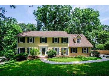 Charming two-story home with yellow siding, green shutters, and a well-manicured lawn at 4503 Rivercliff Sw Dr, Lilburn, GA 30047